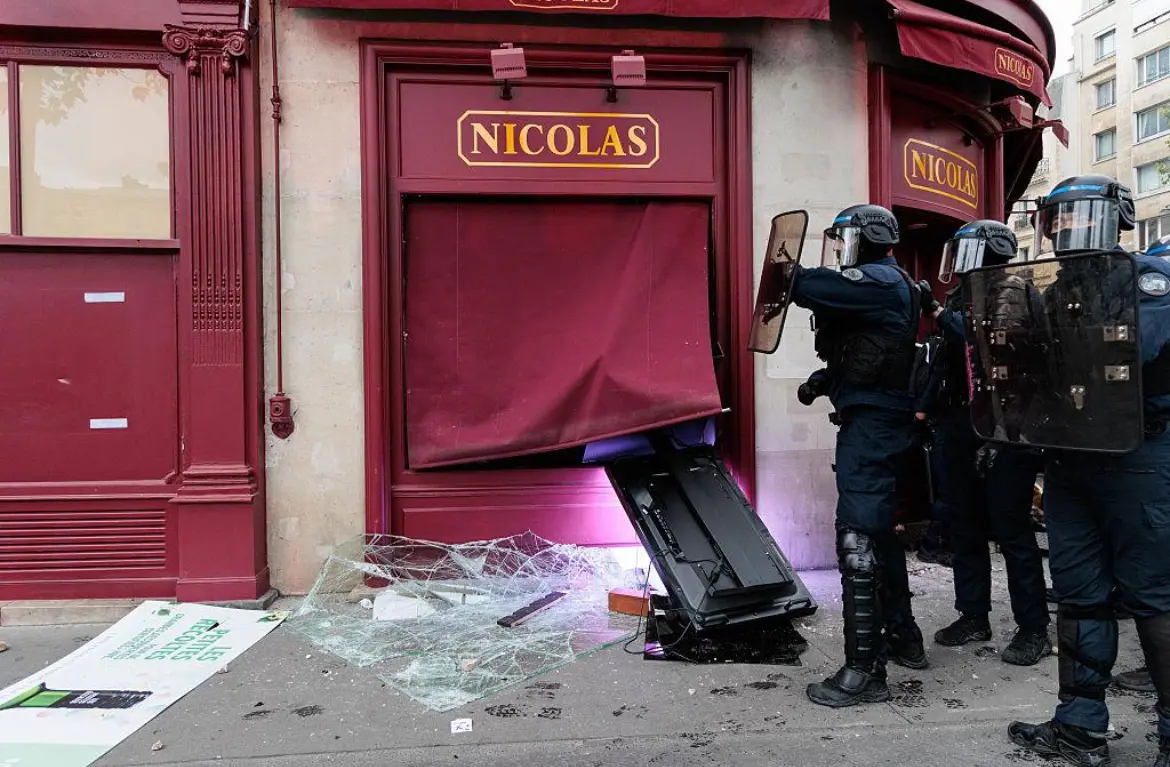 Policiers devant la devanture brisée d’un magasin Nicolas à Paris pendant les mobilisations d’octobre 2026