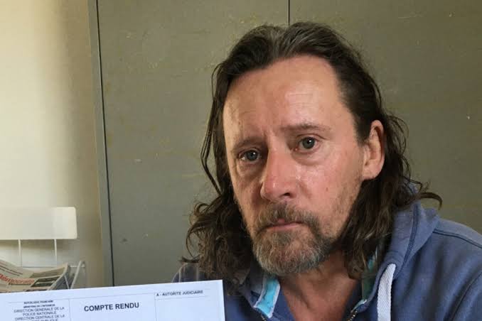 L'acteur Francis Renaud tenant un document, photographie de contexte