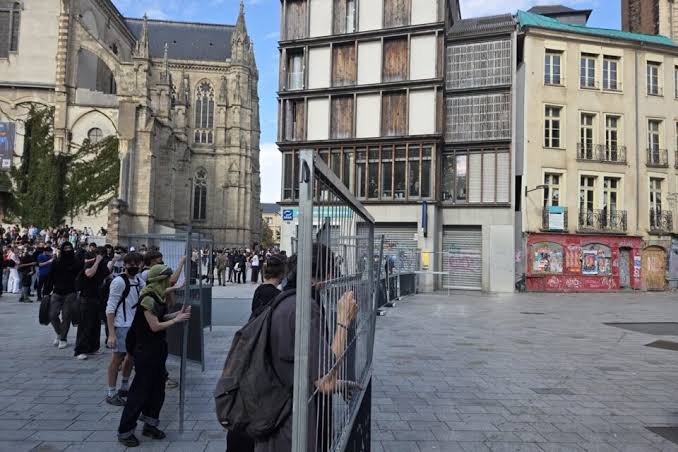Des barrières métalliques et un groupe de personnes dans le centre de Rennes