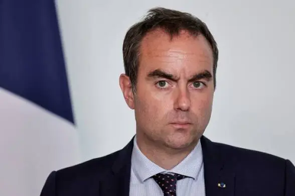 Portrait officiel de Sébastien Lecornu devant un drapeau français, photographie d’illustration
